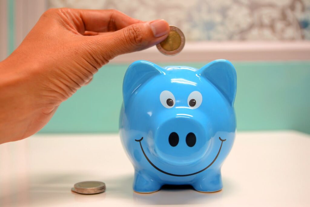 coin being put into blue piggy bank
