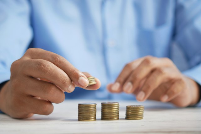 A pair of hands stacking coins