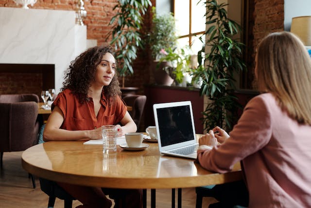Two people across from each other at a table.