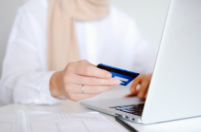 A person paying rent on a laptop with a credit card.
